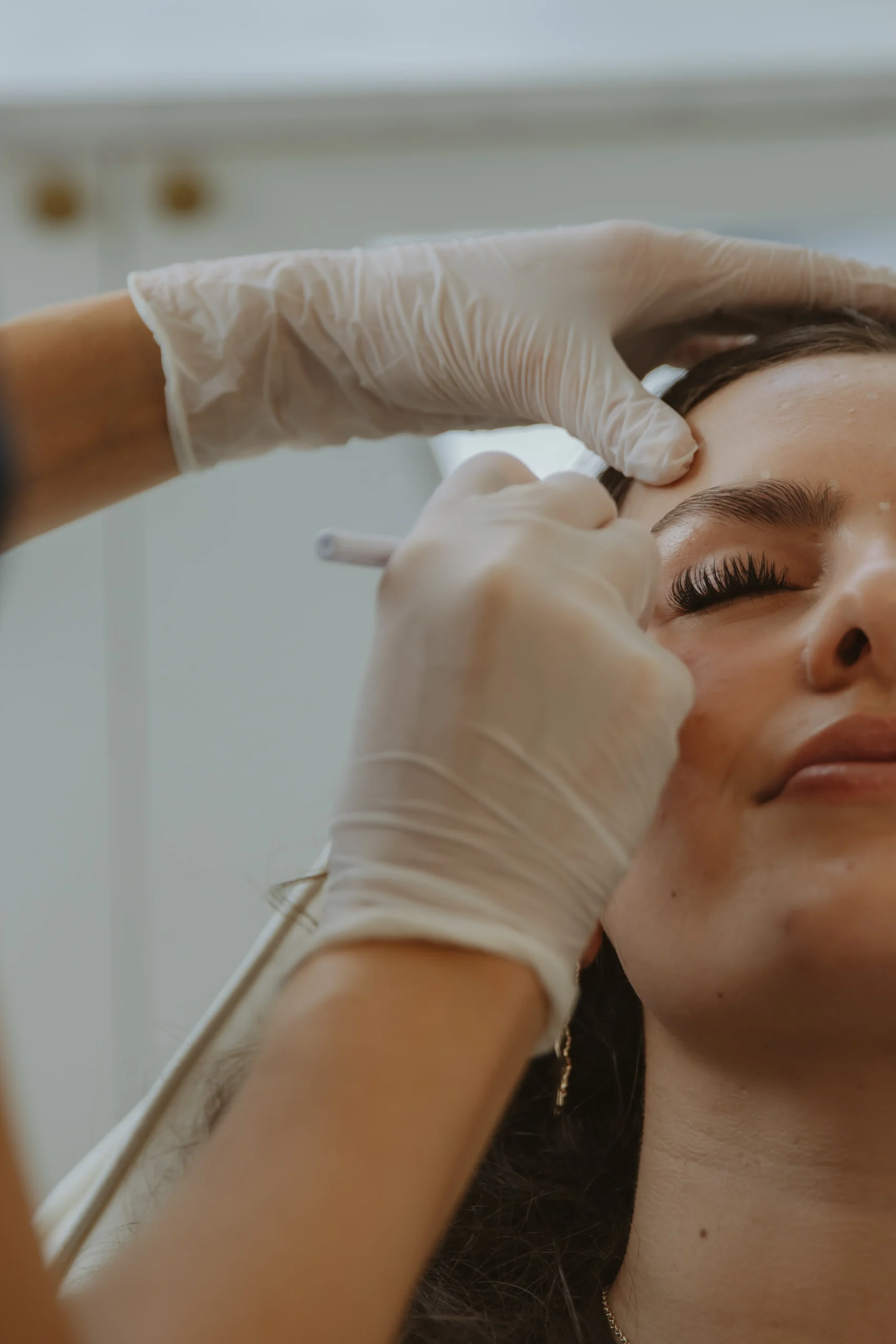 Jasmine performing a precise forehead aesthetics treatment